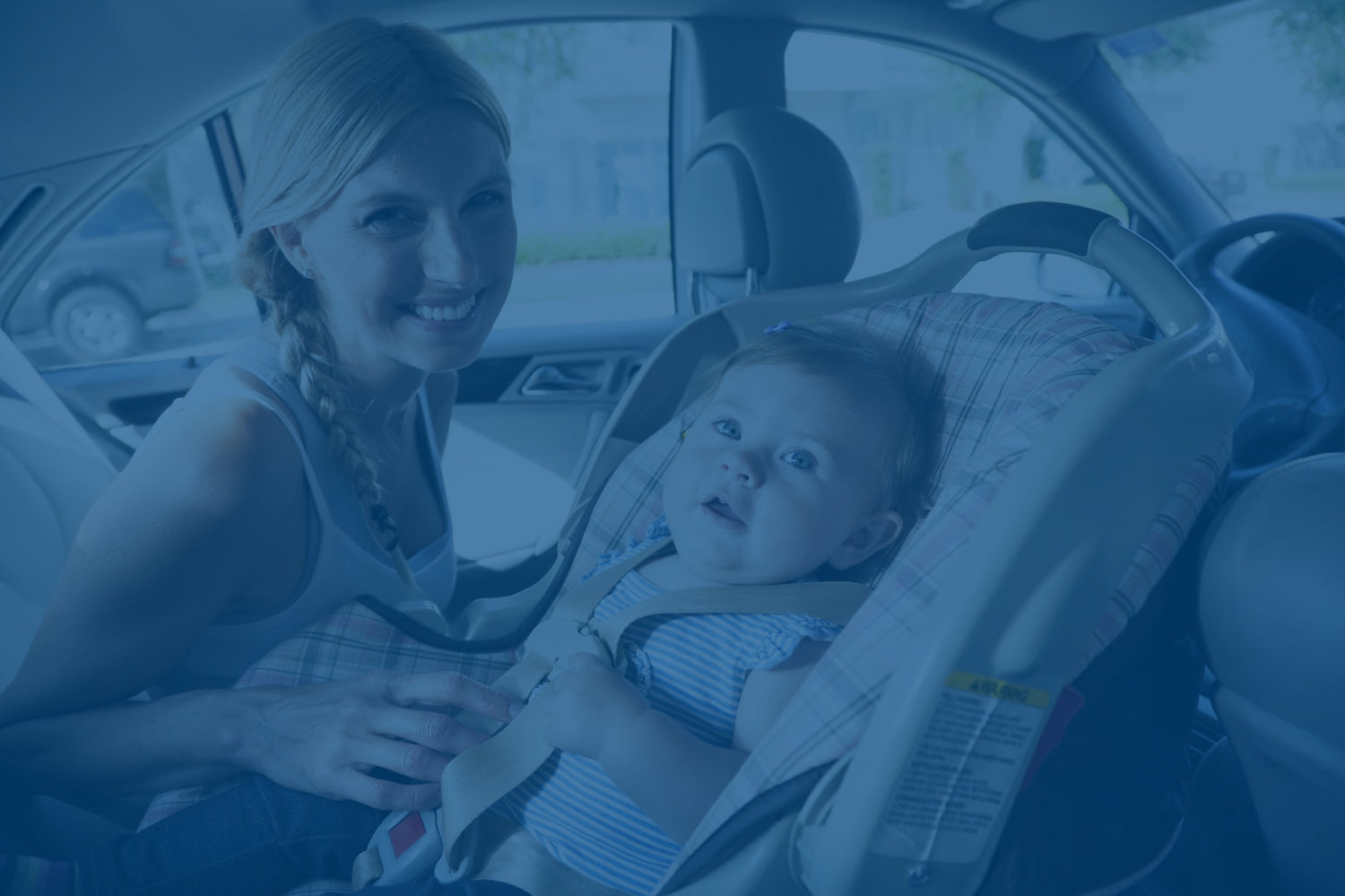 Mom sitting next to baby in carseat